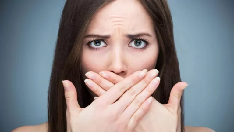 A Women Covering Her Mouth With Her Hands
