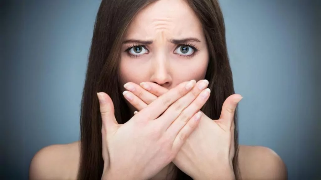 A Woman Covering Her Mouth With Her Hands
